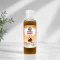 Shudhik castor oil bottle, 100ml, natural oil and ghee for skincare and hair care, with a clear label showing the product.